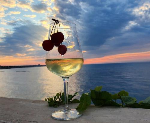 a glass of wine with a bunch of cherries in it at Banfi's villa on the sea in Bisceglie