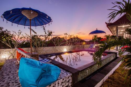 a pool with umbrellas and chairs and a swimming pool at Candiva Family House in Nusa Lembongan