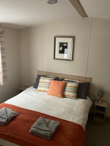 um quarto com uma cama grande e almofadas coloridas em Delightful Holiday Home at River Valley near Penzance em Penzance