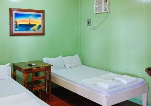 een ziekenhuiskamer met 2 bedden en een tafel bij RedDoorz at July's Haven Seaside Pension Camiguin in Mambajao