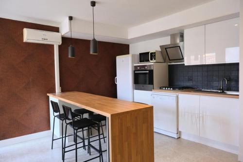 - une cuisine avec des appareils blancs et un comptoir en bois dans l'établissement L'OSTRA de l'impasse, à Portiragnes
