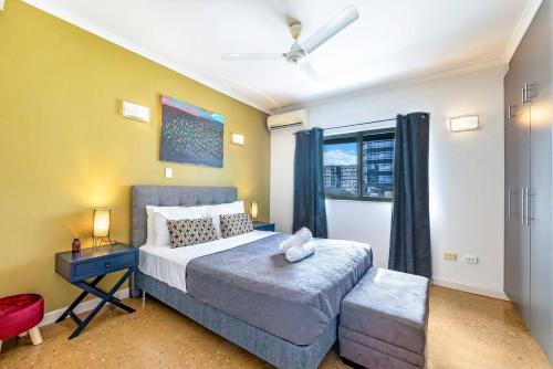 a bedroom with a large bed and a window at Artistic City Escape with Balcony and Parking in Darwin