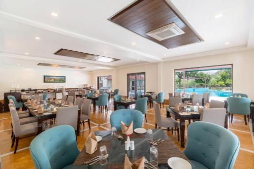 a dining room with tables and blue chairs at Sarasiruham Resort - Private Pool Villa in Udaipur in Udaipur