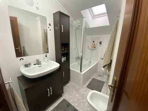 bagno con lavandino, doccia e servizi igienici di usgo beach apartment a Miengo