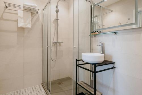 a bathroom with a glass shower and a sink at Townhouse17 Boutique Bed & Breakfast in Victoria