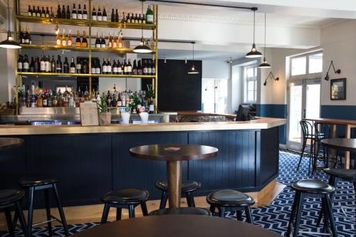 a bar with tables and stools in a restaurant at Blues Point Hotel in Sydney