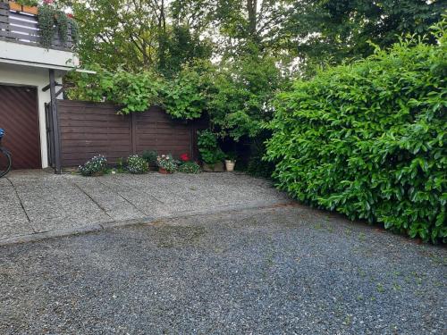 un garage avec clôture et quelques plantes dans l'établissement FeWo Min Egen in Neukirchen, à Neukirchen