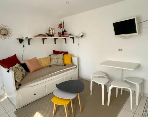 Habitación con sofá, mesa y taburetes en Ty France, en Crozon