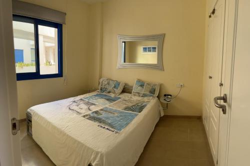 a small bedroom with a bed and a window at Puerto de la Duquesa MINIMUM 3 NUITS in Manilva
