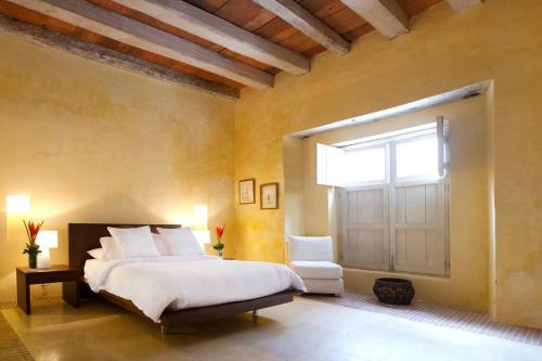 Un dormitorio con una cama grande y una ventana en Casa Pombo Luxury 3 largeBR Duplex old city 300m2, en Cartagena de Indias