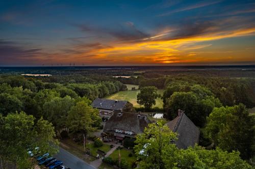an overhead view of a house with trees and a sunset at Hotel Landhaus Höpen in Schneverdingen