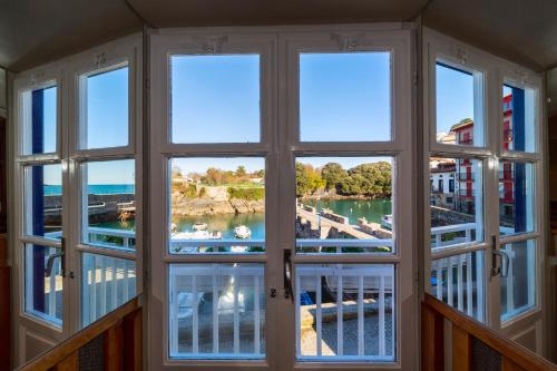 una camera con finestra affacciata su un porto turistico di Hotel&Spa El Puerto a Mundaka