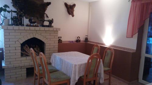 a dining room with a table and a fireplace at Zielone Zacisze in Zagnańsk