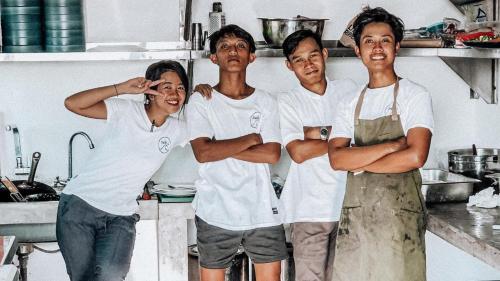 a group of four people standing in a kitchen at Swell Hotel, Pool Bar & Restaurant in Tanah Lot