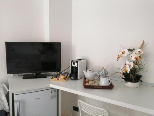 a desk with a television and flowers on it at Due Effe Room in Termoli