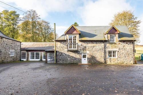 an old stone house with a driveway in front of it at Stunning Luxury Duplex with Hot Tub and AirCon in Glenfarg