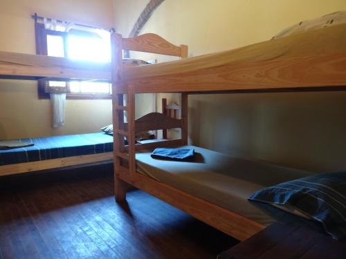 a bedroom with two bunk beds and a window at Tree House Hostel in Salto de las Rosas