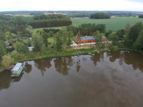 an aerial view of a house next to a lake at le bateau sur lac privé de 2 hectares poissonneux au milieu des bois in Florennes