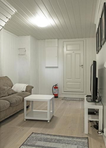a living room with a couch and a table and a tv at Naturnær leilighet med 1 soverom in Sandnes