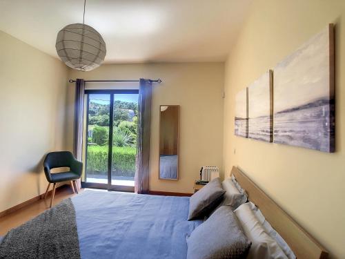 ein Schlafzimmer mit einem Bett, einem Stuhl und einem Fenster in der Unterkunft Hillside House by LovelyStay in Achadas da Cruz