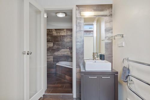 ein Badezimmer mit einem Waschbecken und einer Badewanne in der Unterkunft 2 bedroom apartment in the heart of the city! in Bendigo