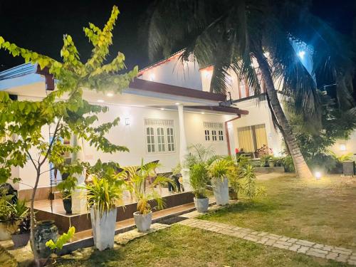 a house with a lot of plants in front of it at White Villa Airport Transit Hotel in Katunayake