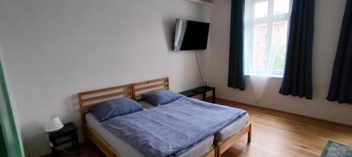 a bedroom with a bed with blue sheets and a window at Apartment Spielberk in Brno