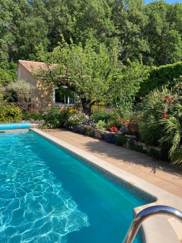 - une piscine à côté d'un jardin fleuri dans l'établissement Les Hauts d'Eyragues gîte Aigue Marine Meublé classé 4 étoiles, à Eyragues