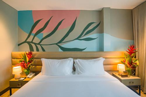 a bedroom with a large bed and a painting on the wall at 1521 Hotel & Spa in Mactan