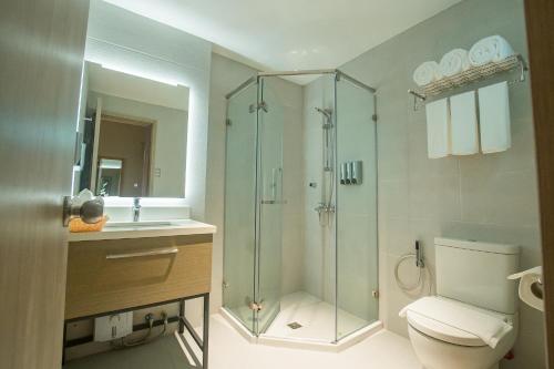 a bathroom with a shower and a toilet and a sink at 1521 Hotel & Spa in Mactan