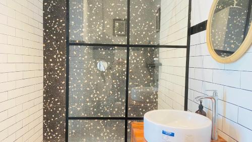 une salle de bain avec une douche avec un lavabo et un miroir dans l'établissement Keyla Canggu Villa, à Canggu