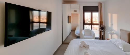 a bedroom with a large flat screen tv on a wall at BnBIsrael apartments - Markolet Camelia in Tel Aviv