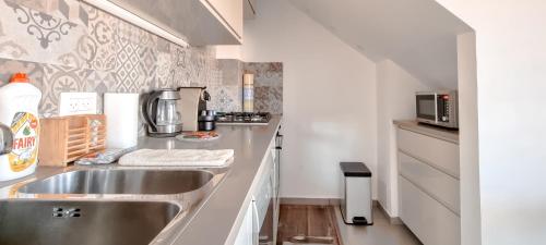 a kitchen with a stainless steel sink and a microwave at BnBIsrael apartments - Markolet Camelia in Tel Aviv