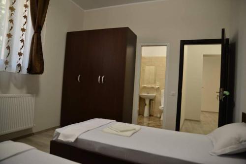 1 dormitorio con 2 camas, lavabo y espejo en Casa Stefan Galati en Galaţi