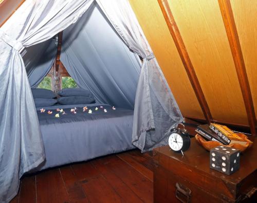 a room with a bed in a tent with dice at The Hidden Escapes Manggis- Stunning Tiny Home set on a Lake with Mountain View, Private Sauna, Pool, Bicycles, BBQ & Butler! in Padangbai