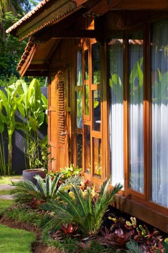 a wooden house with some plants in a yard at The Hidden Escapes Manggis- Stunning Hidden Gem Villa with Pool, Sauna & Ice Bath in Padangbai