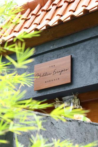 a sign on the side of a building with a roof at The Hidden Escapes Manggis- Stunning Hidden Gem Villa with Pool, Sauna & Ice Bath in Padangbai
