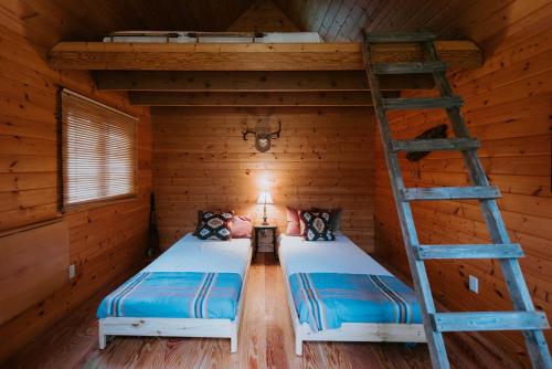 2 Betten in einem Holzzimmer mit einer Leiter in der Unterkunft Serene, Tranquil, Oasis with stunning ocean views of Pender Harbour in Garden Bay