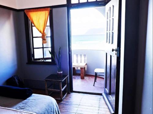 a bedroom with a door open to a room with a view at African Soul Surfer in Muizenberg