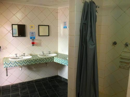a bathroom with two sinks and a shower at African Soul Surfer in Muizenberg