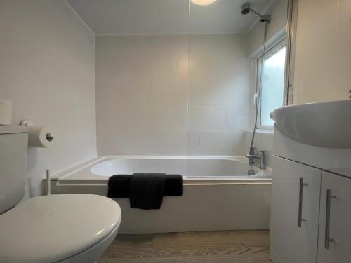a bathroom with a tub and a toilet and a sink at Tropical Apartment, 10 min from Blackpool tower, outside space, sleeps 12 in Blackpool