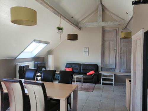 uma sala de estar com uma mesa e cadeiras e um sofá em Gîte Ferme d'hurtaux em Froid-Chapelle