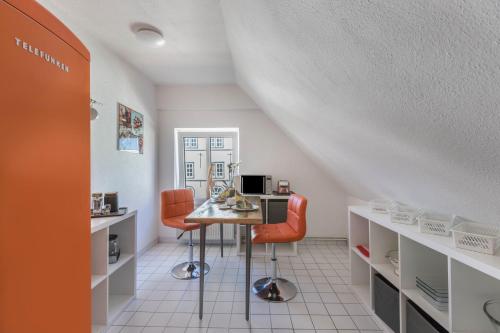 a room with a table and two chairs and a desk at Blumenhaus-apartment Friedrichstadt in Friedrichstadt