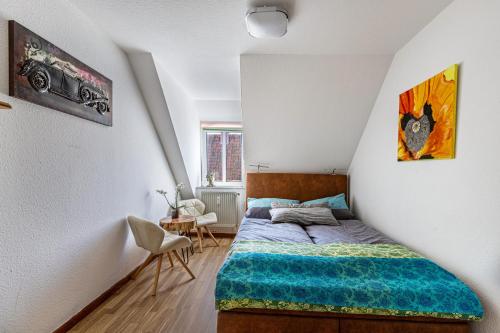a small bedroom with a bed and a table at Blumenhaus-apartment Friedrichstadt in Friedrichstadt