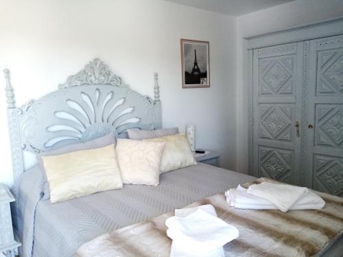 a bedroom with a white bed with white pillows at Vivenda das Carvalhas in Amiar