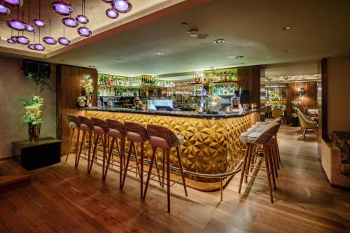 a bar with brown stools in a restaurant at Fairmont Hotel Vier Jahreszeiten in Hamburg