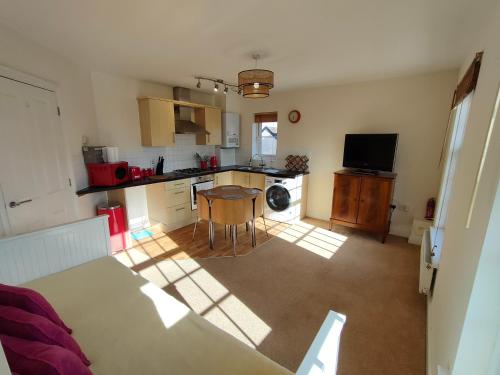 a kitchen with a table and a kitchen with a counter top at Central Taunton 2-bedroom apartment, great location! in Taunton