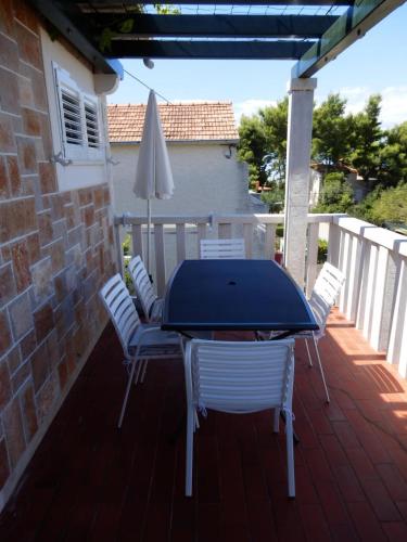 a patio with a table and chairs and an umbrella at Apartments Vesna & Ivica in Mirce