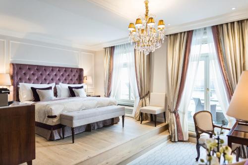 Un dormitorio con una cama grande y una lámpara de araña. en Fairmont Hotel Vier Jahreszeiten, Hotel des Jahres 2023 & 2024- Die 101 Besten en Hamburgo