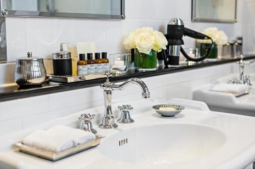 a bathroom with a sink and a mirror at Fairmont Hotel Vier Jahreszeiten in Hamburg